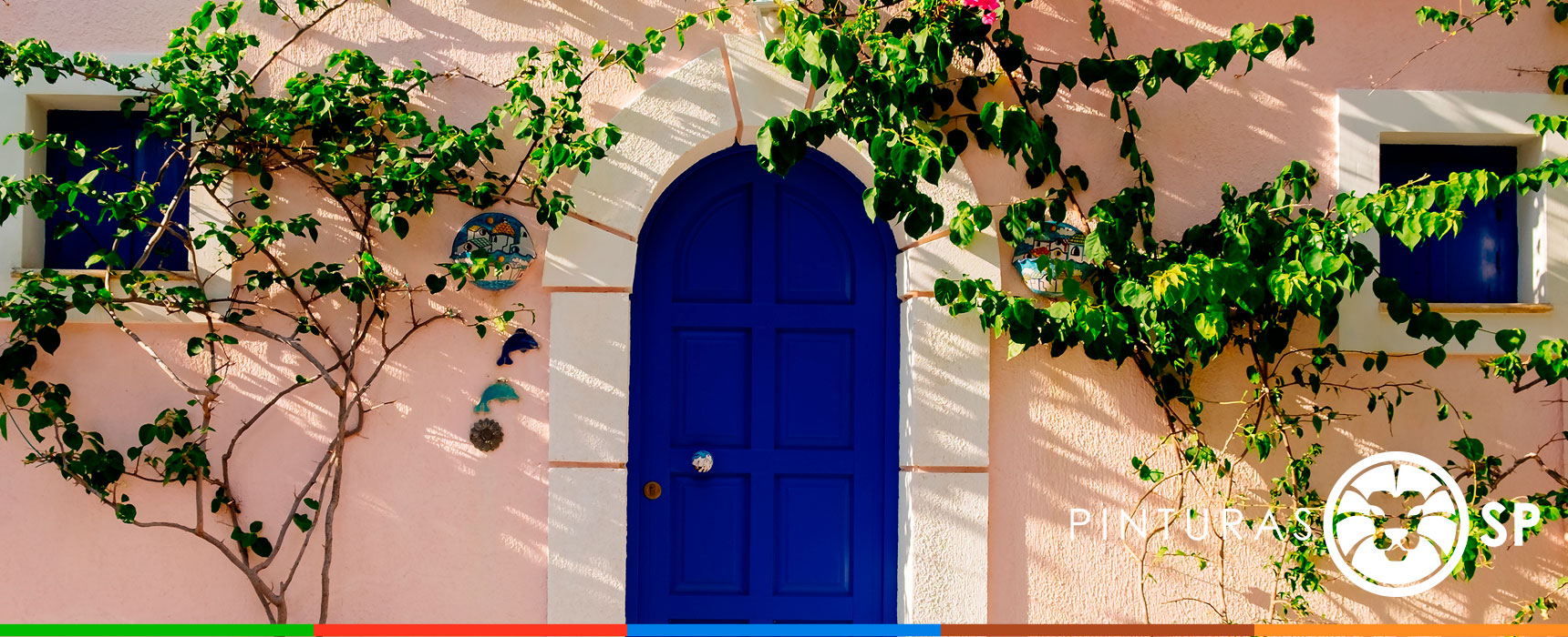 Puerta azul en una fachada con vegetación